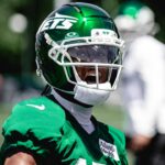 Jets wide receiver Adonai Mitchell practices in a green helmet and jersey