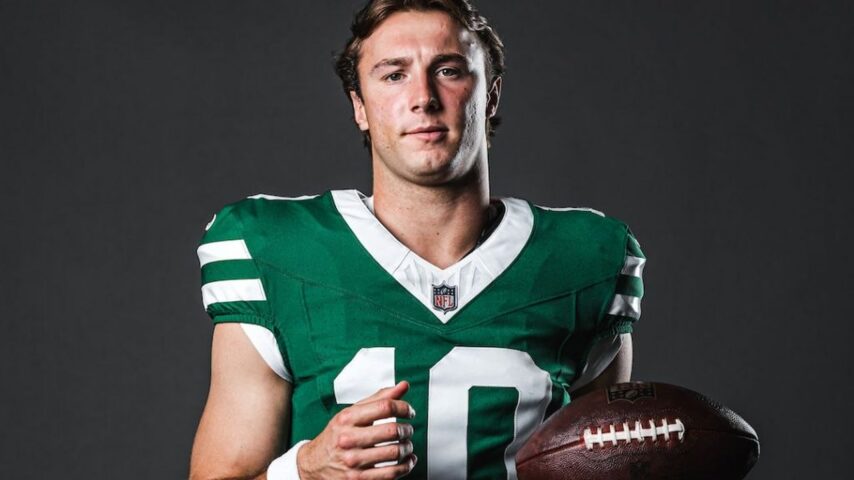 Cade Klubnik in a green New York Jets No. 10 uniform holding a football.