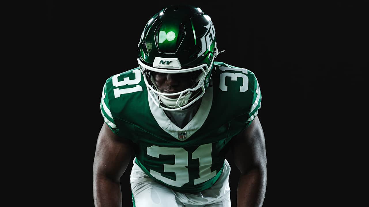 New York Jets player in a green uniform against a black background