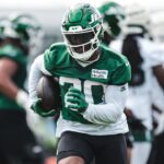 Breece Hall carries a football during the Jets' first 2026 training camp practice.