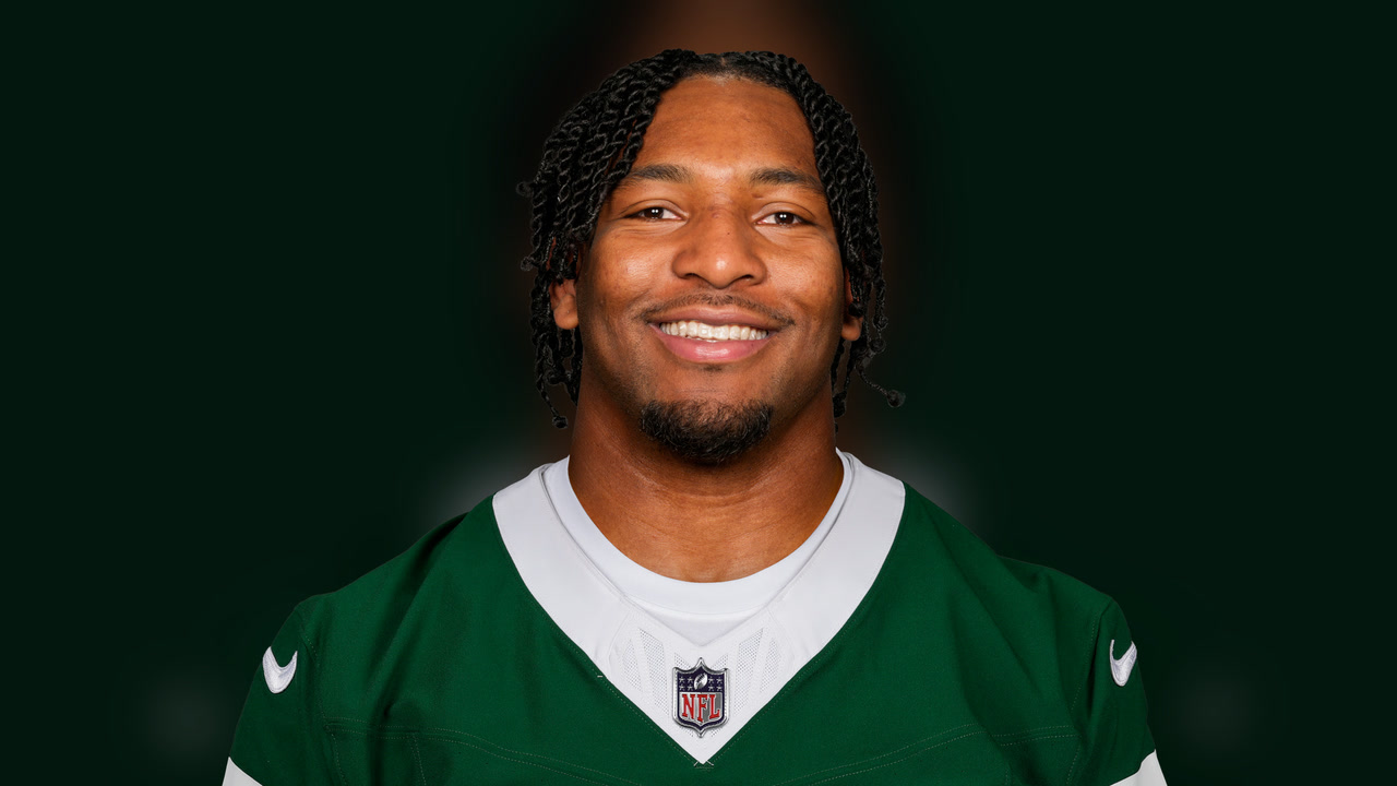 Kingsley Enagbare wearing a green New York Jets jersey.