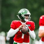 Geno Smith holds the football during New York Jets practice on August 18, 2026.