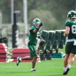 Jets wide receiver Garrett Wilson holds a football during training camp practice.